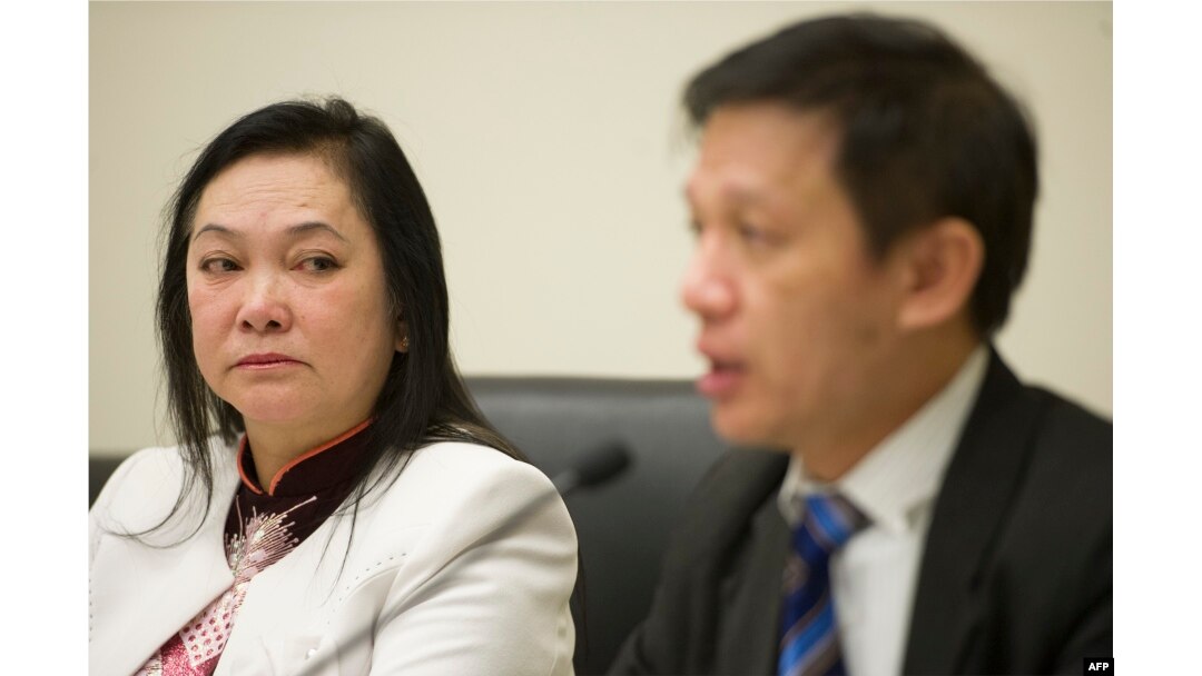Tran Thi Ngoc Minh, the mother of jailed Vietnamese labor activist Do Thi Minh Hanh, listens as Nguyen Dinh Thang of Boat People SOS (R) speaks about torture and abuse of political and religious prisoners in Vietnam during a press conference on Capitol Hill, Jan. 16, 2014.