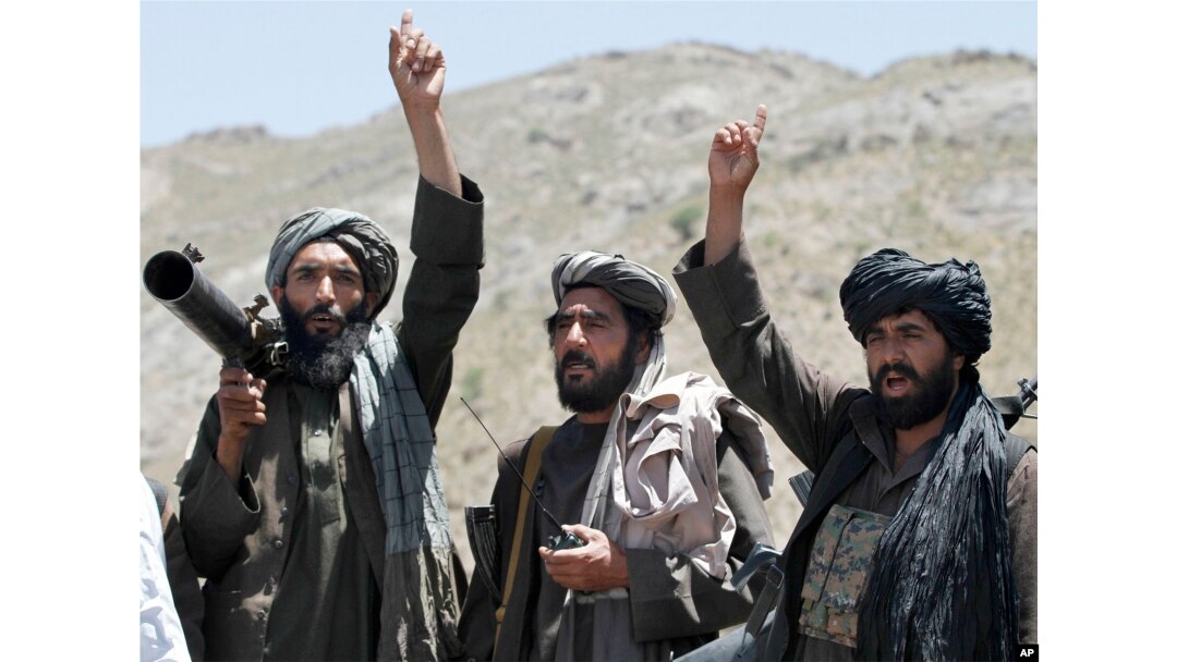 FILE - Taliban fighters react to a speech by their senior leader in the Shindand district of Herat province, Afghanistan.