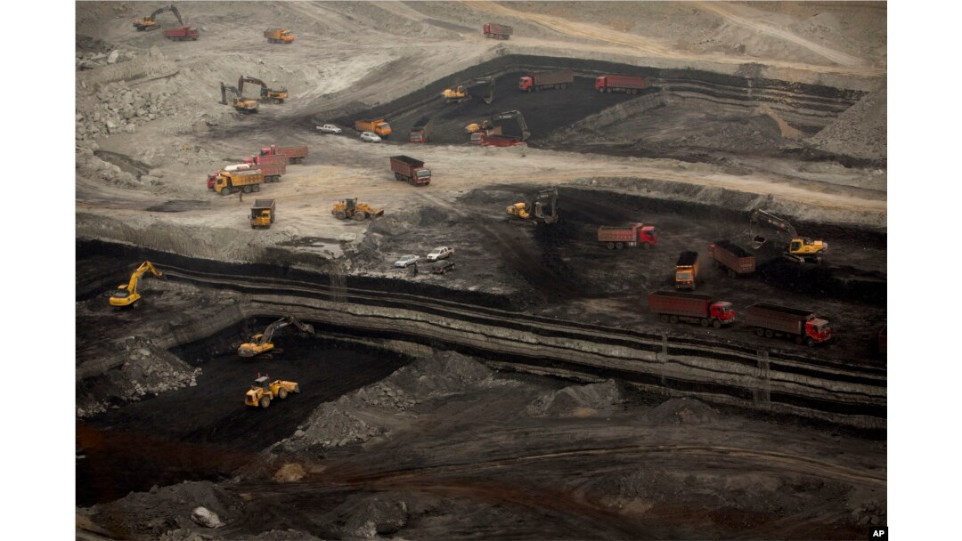 FILE - Vehicles work at an open-pit coal mine near Ordos in northern China's Inner Mongolia Autonomous Region.