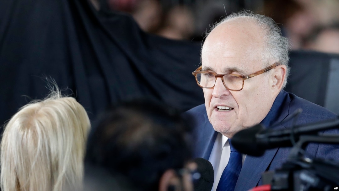 ARCHIVO - El exalcalde de la ciudad de Nueva York, Rudy Giuliani, habla con los dolientes antes de un funeral en la Biblioteca Billy Graham para el reverendo Billy Graham, el 2 de marzo de 2018, en Charlotte, Carolina del Norte.