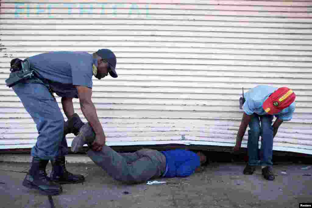 Police arrest a school pupil for lootingin the South African township of Soweto, where foreign shop owners were attacked and at least two killed, Aug. 29, 2018.