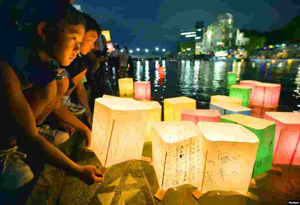People release paper lanterns on the Motoyasu river facing the gutted Atomic Bomb Dome in remembrance of atomic bomb victims on the 69th anniversary of the bombing of Hiroshima, August 6, 2014.