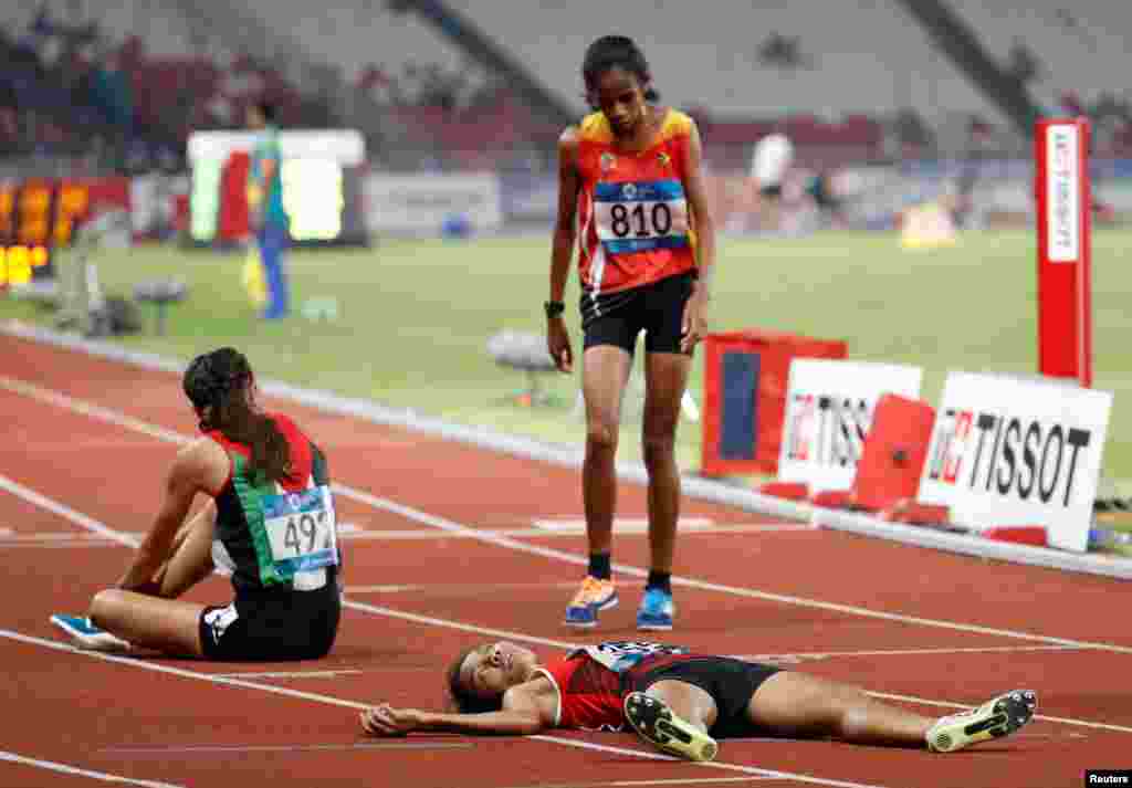 Odekta Elvina Naibaho of Indonesia collapses after women's 5000m athletics final during the 2018 Asian Games in Jakarta, Indonesia.