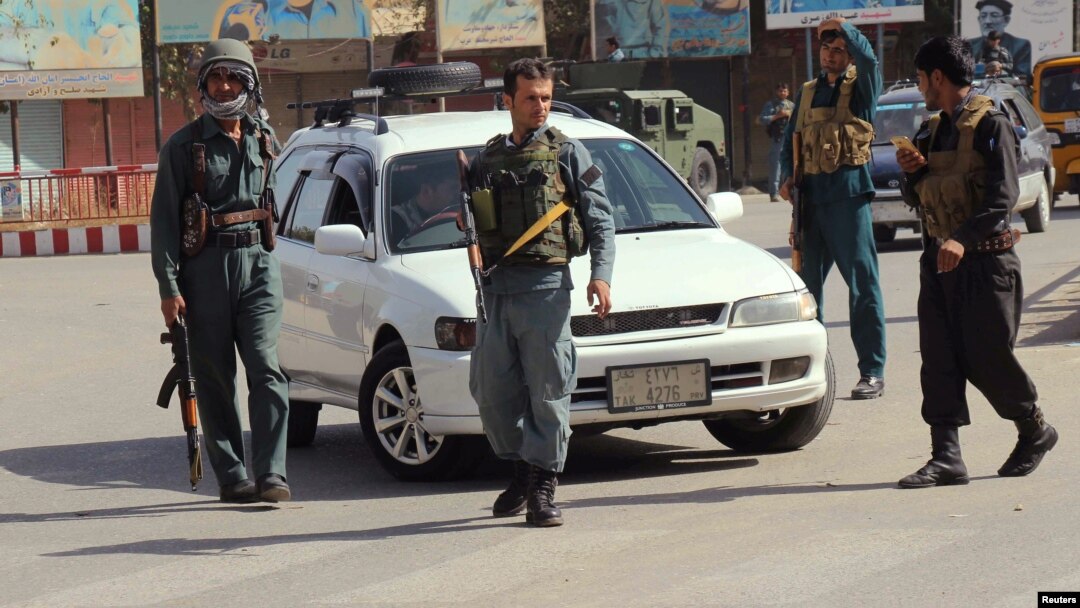 Afghan policemen keep watch in the downtown of Kunduz city, Afghanistan, Oct. 3, 2016.