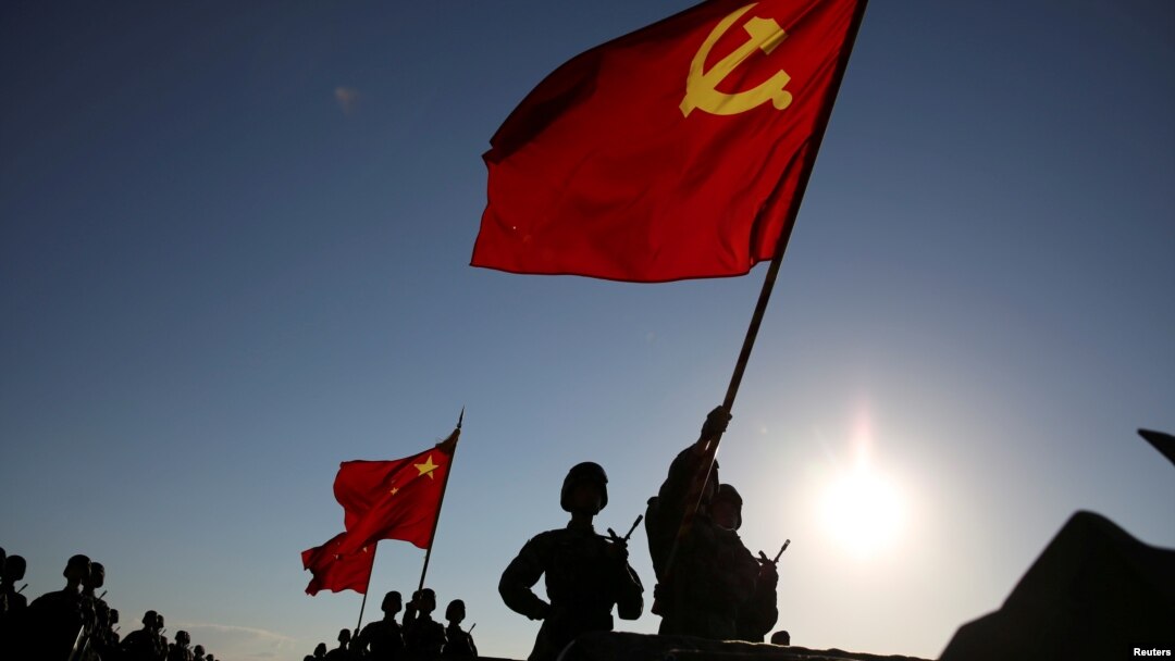 中國解放軍軍人在內蒙古朱日和訓練基地準備參加閱兵，慶祝解放軍建軍90週年。中共黨旗在前，國旗居中，軍旗在後（2017年7月30日）