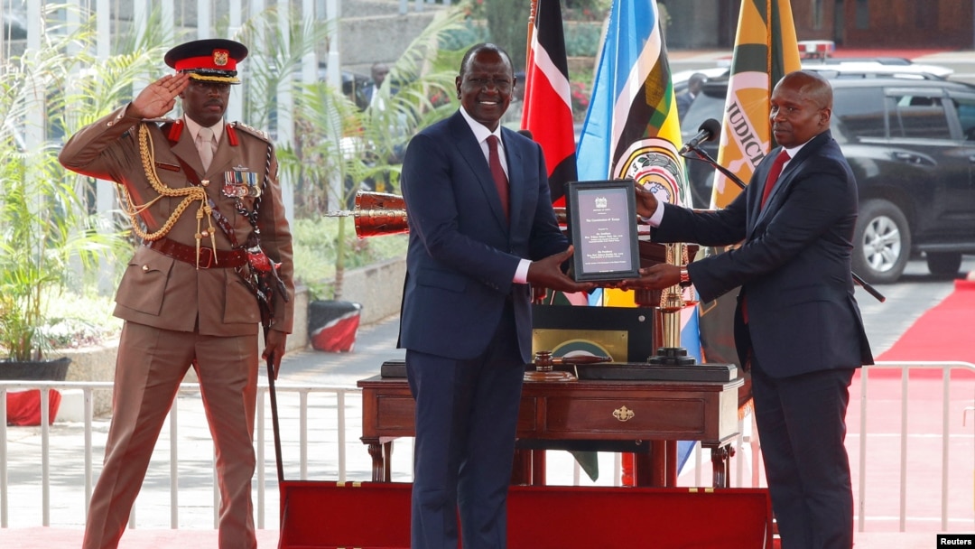 Kenya's President William Ruto hands over the Kenyan constitution to Deputy President Kithure Kindiki after he took the oath of office during his swearing-in ceremony, Nov. 1, 2024.