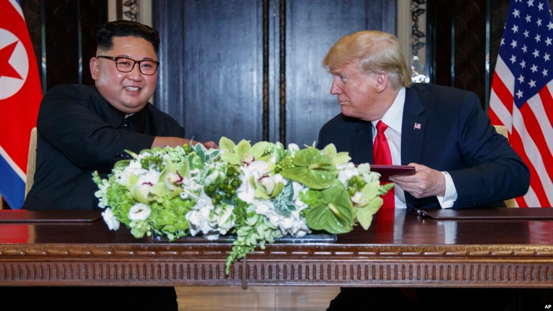도널드 트럼프 미국 대통령과 김정은 북한 국무위원장이 지난 2018년 6월 싱가포르에서 열린 첫 정상회담에서 합의문에 서명한 후 악수하고 있다.