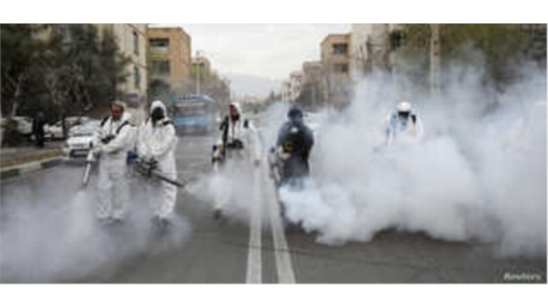 FILE - Members of firefighters wear protective face masks, amid fear of coronavirus disease (COVID-19), as they disinfect the streets, ahead of the Iranian New Year Nowruz, March 20, in Tehran, March 18, 2020.