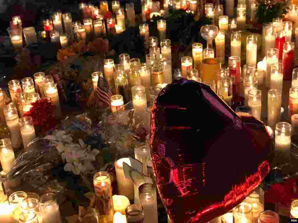 A red heart-shaped balloon flies over lit candles honoring the victims of the Las Vegas shooting, Oct. 2, 2017. (Photo: S. Dizayee / VOA Turkish Service)