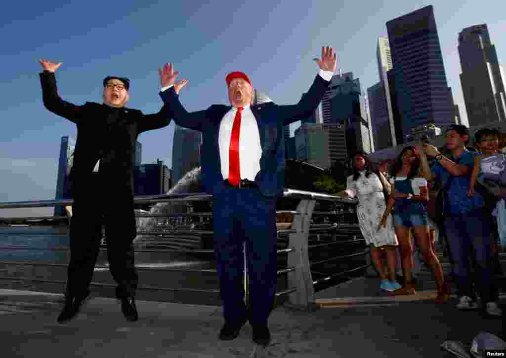 Howard, dan kasar Australia-dan asalin kasar China ya yi shigar shugaban Koriya Ta Arewa Kim Jong-un, da Dennis Alan, wanda ya yi shigar shugaban Amurka Donald Trump, sun gana a wurin shakatawa na Merlion Park a Singapore, June 8, 2018.