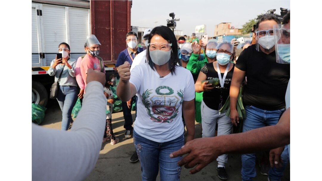 ARCHIVO - La candidata presidencial de Perú, Keiko Fujimori, quien se enfrentará a Pedro Castillo en una segunda vuelta en las elecciones de junio, saluda a sus partidarios en un mercado de frutas y verduras, en Lima. Abril 21 de 2021.