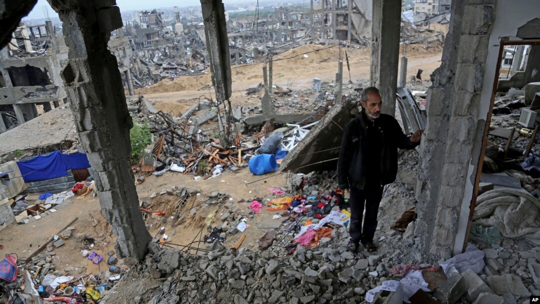 FILE - A man stands in rubble of his house, destroyed in this year's Israel-Hamas conflict, in the Shijaiyah neighborhood of Gaza City, Nov. 24, 2014.