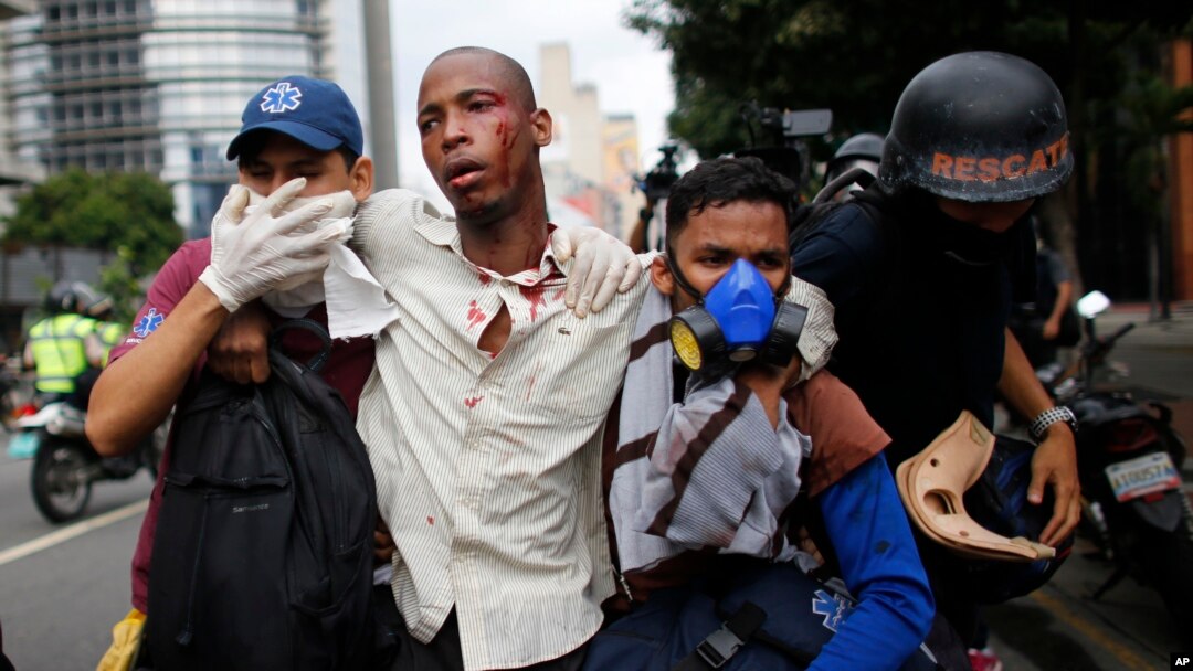 Los paramédicos asisten a un hombre herido durante las protestas y enfrentamientos entre las fuerzas de seguridad y la oposición. 