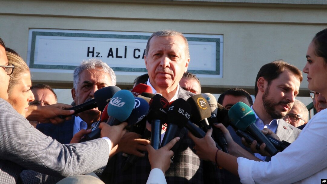 Turkey's President Recep Tayyip Erdogan, center, talks to members of the media outside a mosque following Eid prayers in Istanbul, Sept. 1, 2017.