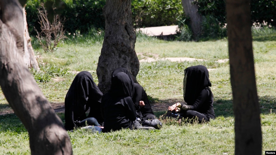 FILE - Veiled women sit in a garden in the northern province of Raqqa, Syria, March 31, 2014. The Islamic State has imposed strict new dress codes on women.