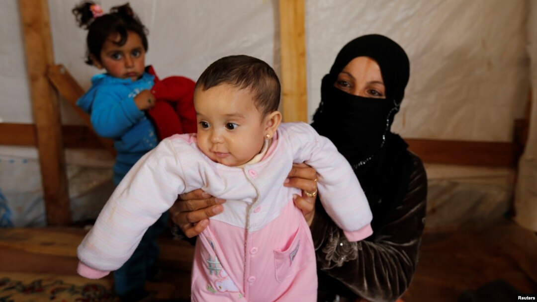 FILE - Syrian refugee Asheqa holds her unregistered baby daughter Nour inside a tent at a refugee camp near the town of Baalbek in Lebanon's Bekaa valley, March 3, 2016. (REUTERS/Mohamed Azakir)