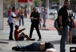 Civil police detain looters after they were shot in their legs, in Vitoria, Espirito Santo state, Brazil, Feb. 6, 2017.