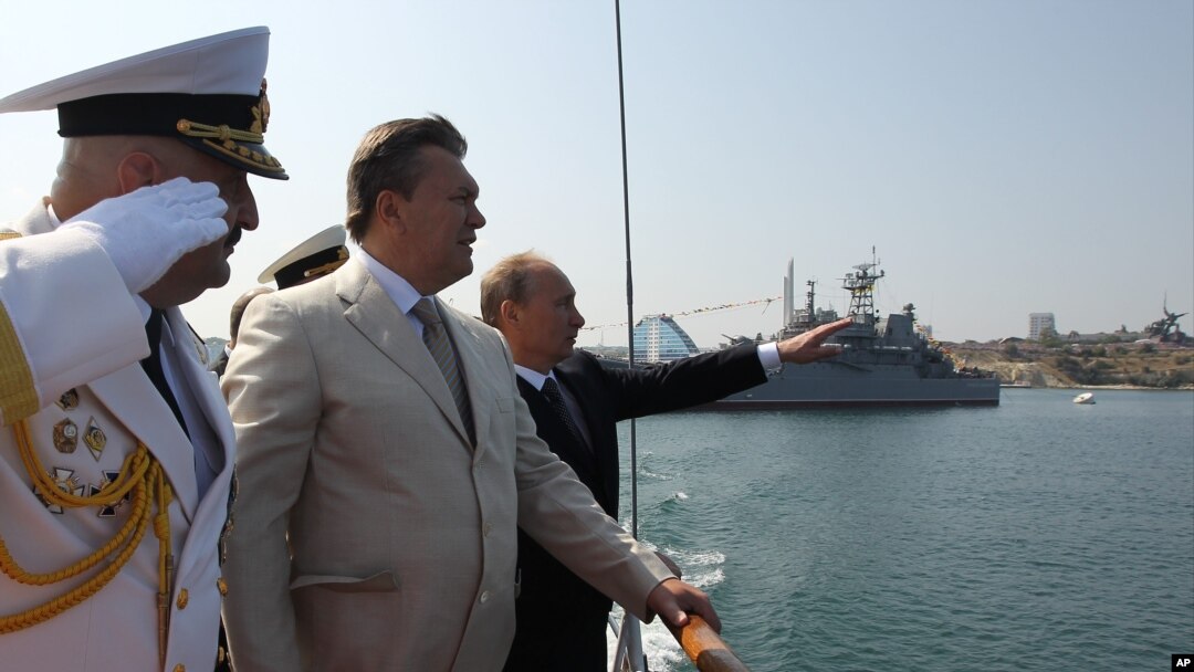 Ukrainian President Viktor Yanukovych, second left, inspects navy ships with Russian President Vladimir Putin in the Ukrainian Black Sea port of Sevastopol in the Crimea, July 28, 2013.