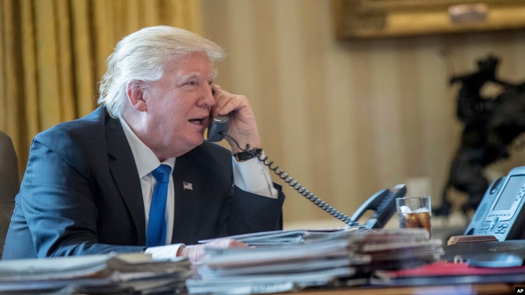 President Donald Trump speaks on the phone with Russian President Vladimir Putin, Jan. 28, 2017, in the Oval Office at the White House in Washington. 