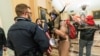 En esta foto, un simpatizante del presidente Donald Trump es confrontado por policías del Capitolio en las afueras de la sala del Senado en el Capitolio el 6 de enero. 