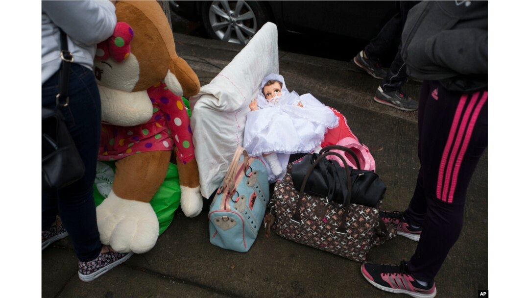 Neighbors organize their belongings on the sidewalk as they collect items from their earthquake-damaged building in the Ciudad Jardin neighborhood of Mexico City, Sept. 21, 2017.