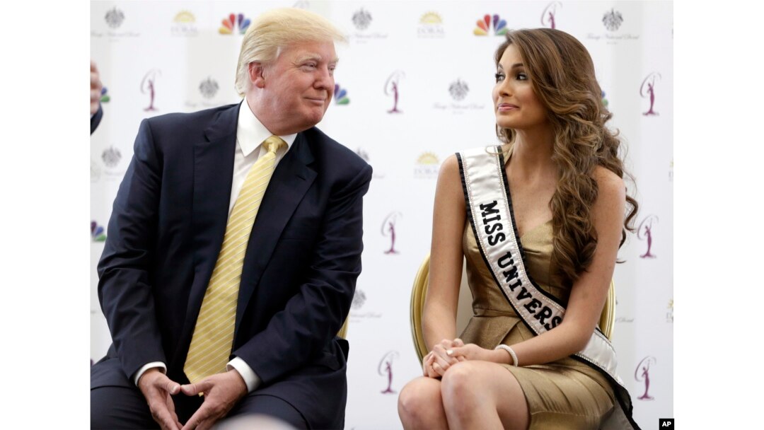 FILE - Donald Trump, left, appears with 2014 Miss Universe, Venezuela's Gabriela Isler. Univision has dropped the pageant.