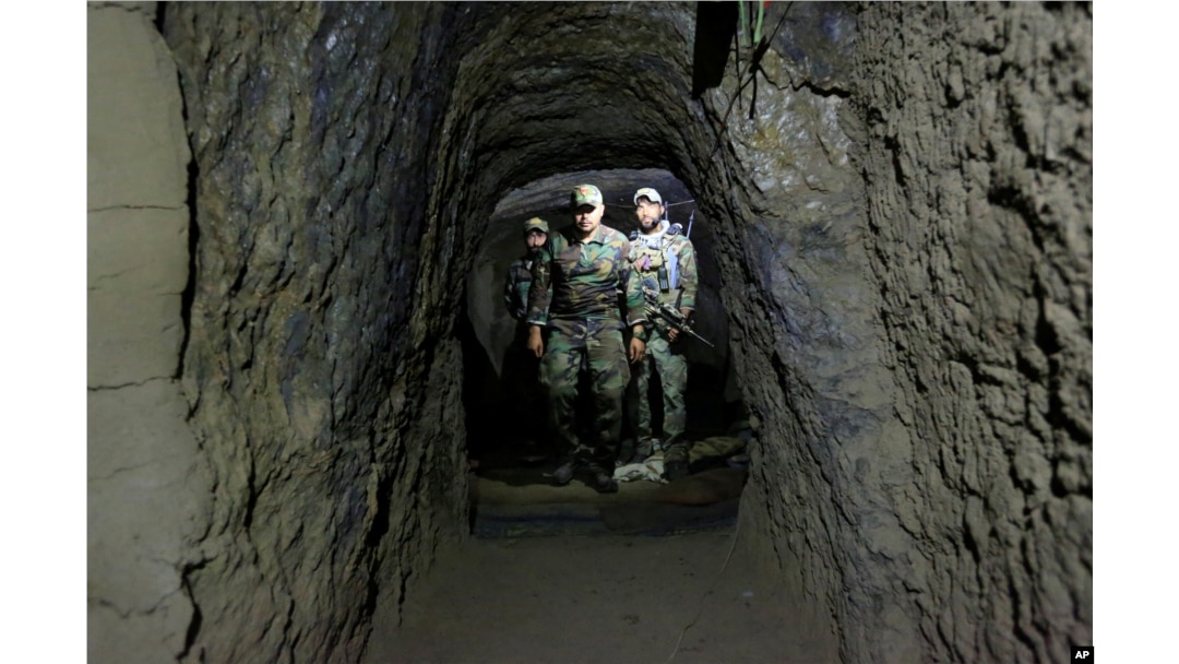 FILE - Afghan Special Forces inspect inside a cave which was used by suspected Islamic State militants at the site where a MOAB, or ''mother of all bombs,'' struck the Achin district of the eastern province of Nangarhar, Afghanistan, April 23, 2017.