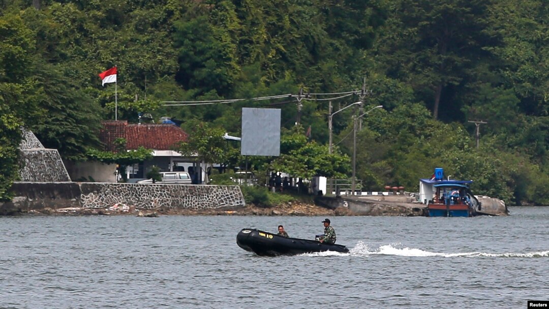 FILE - Indonesian military patrol in a small inflatable boat near a ferry boat dock on the prison island of Nusakambangan, in the background, in Central Java. March 3, 2015. Aman Abdurrahman is being held at Nusakambangan.