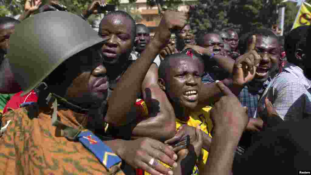 Anti-government protesters chant slogans in front of army headquarters in Ouagadougou, capital of Burkina Faso, Oct. 31, 2014.