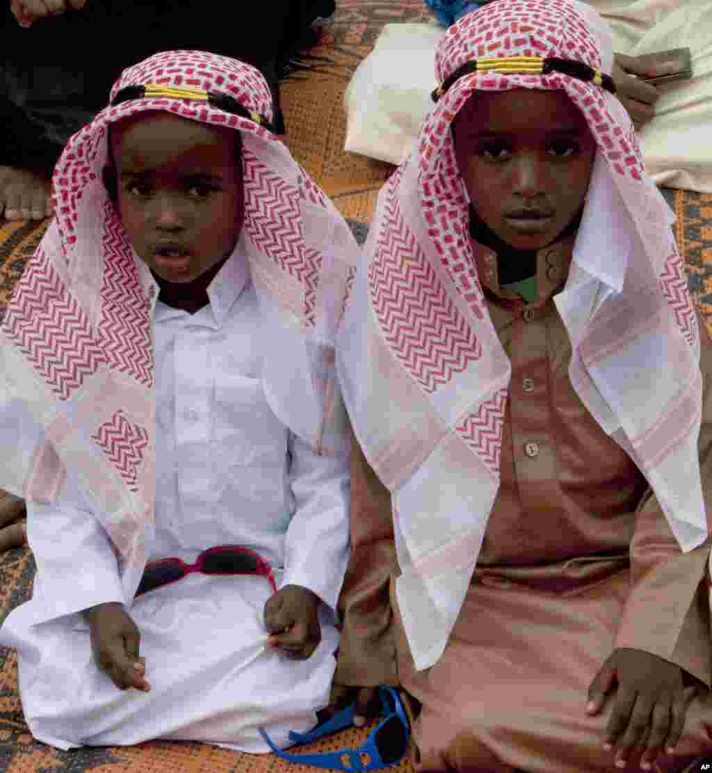 Kenyan children join others to offer prayers outside the Masjid Noor mosque during the first day of Eid al-Fitr, the end of the holy fasting month of Ramadan, in Nairobi, Kenya, July 28, 2014.