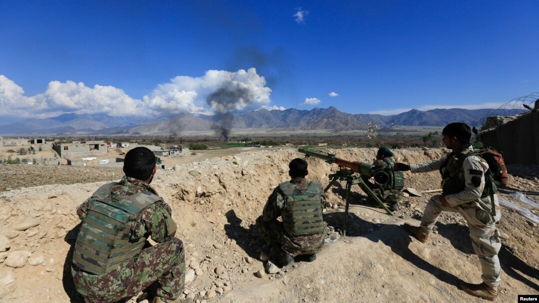 FILE - Afghan security forces take position during a gun battle between Taliban and Afghan security forces in Laghman province, Afghanistan, March 1, 2017. 