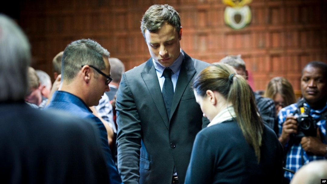 FILE - Oscar Pistorius cries as he prays with his sister Aimee and brother Carl in the magistrates court in Pretoria, South Africa, Aug. 19, 2013. 