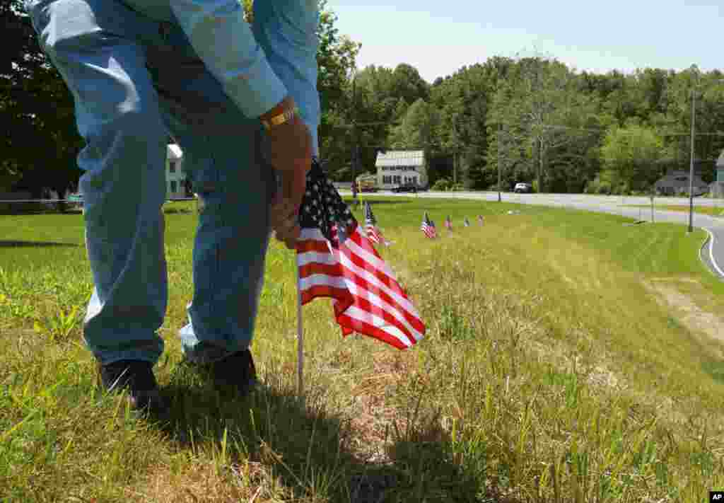 Jim Stull, 78, a life long resident of Thurmont, Maryland, places American flags along an exit ramp that will be traveled by dignitaries motorcading to Camp David for the G-8 Summit.