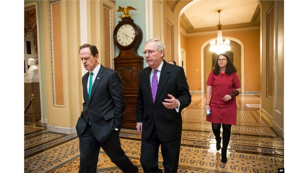 Senate Majority Leader Mitch McConnell, center, walks with Sen. Pat Toomey to the chamber for the vote to impose more stringent sanctions on North Korea, Feb 10, 2016.