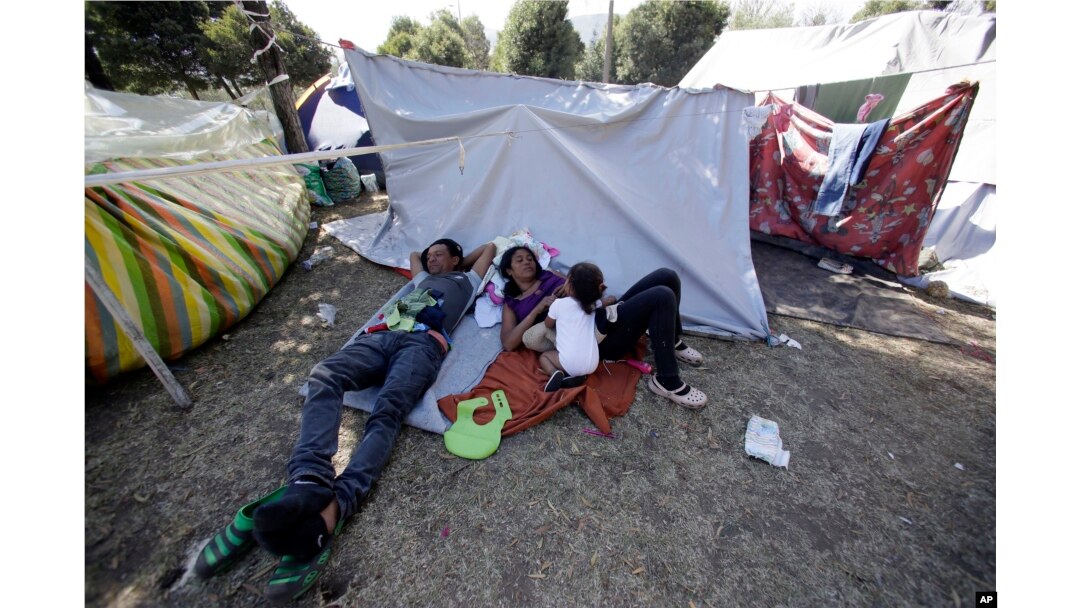 A Venezuelan refugee family rests outside a makeshift camp before going out to find any kind of work in Quito, Ecuador, Aug. 9, 2018.