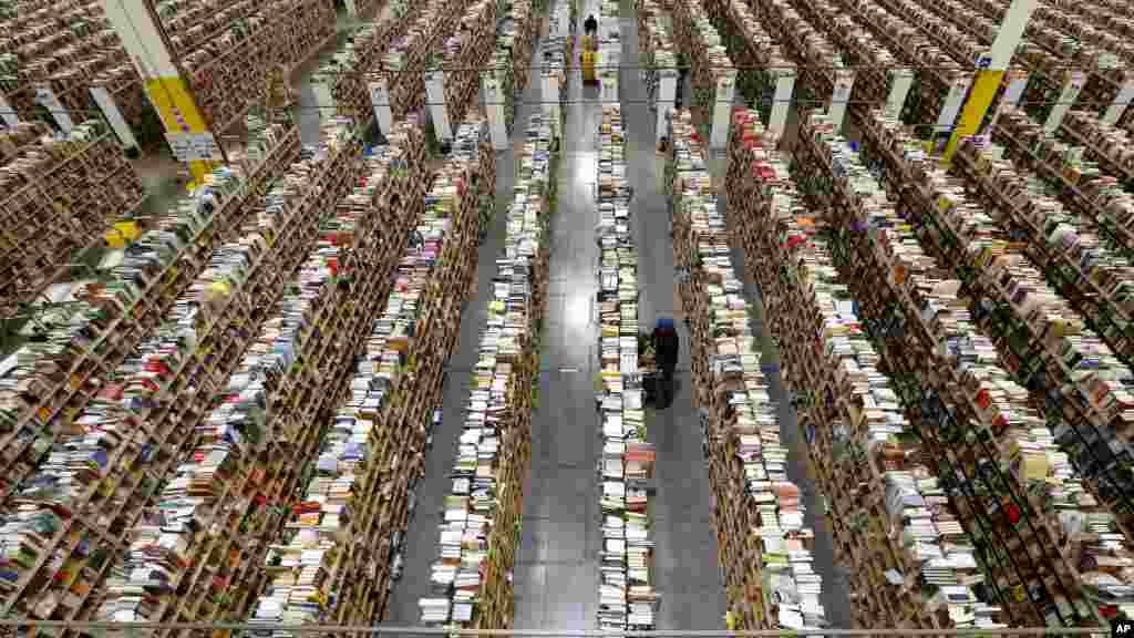 An Amazon.com employee stocks products along one of the many miles of aisles at an Amazon.com Fulfillment Center on "Cyber Monday" the busiest online shopping day of the holiday season in Phoenix, Arizona, USA, Dec. 2, 2013.