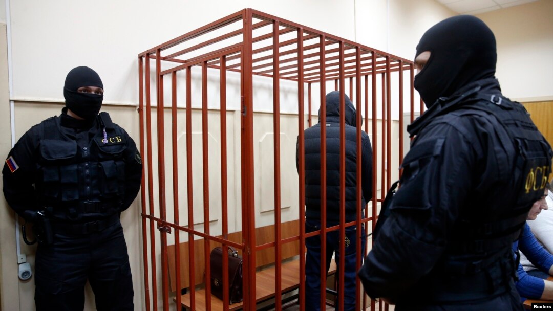 FILE - A defendant stands inside a special cage as he attends a court hearing in Sakhalin, Russia, March 4, 2015. The number of people imprisoned in Russia on extremism-related charges jumped from 137 in 2011 to 414 in 2015, according to independent research.
