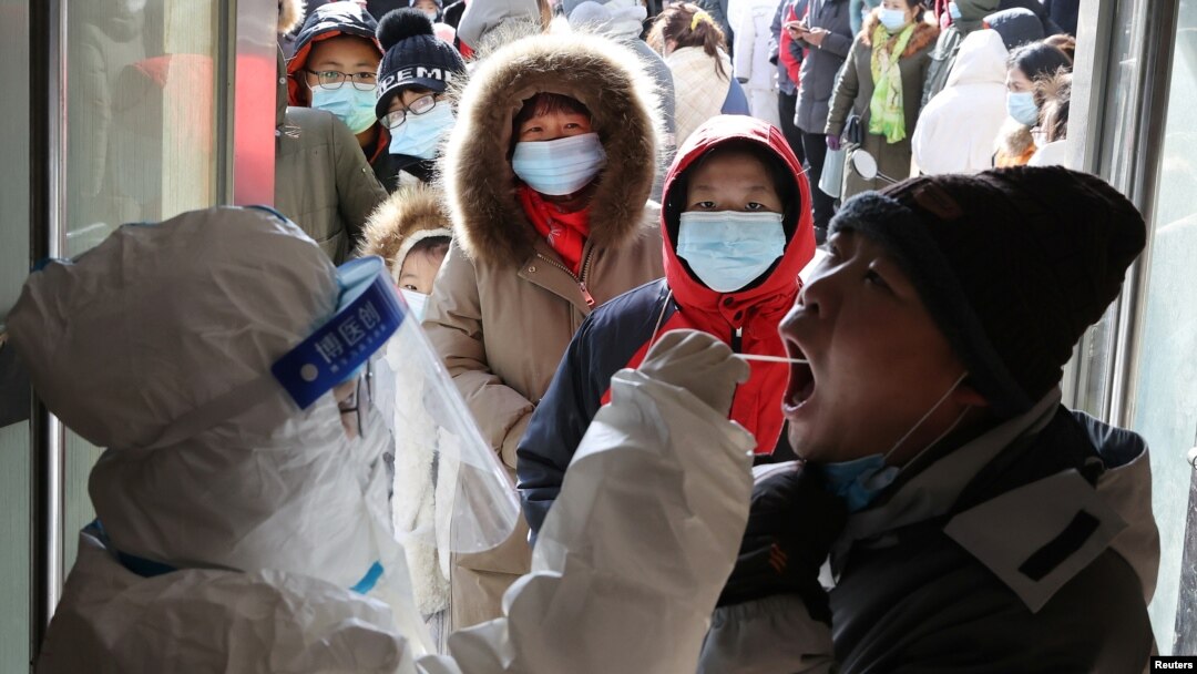 中國河北省石家莊一名身穿防護服的醫護人員在給居民做病毒核酸檢測。（2021年1月6日）