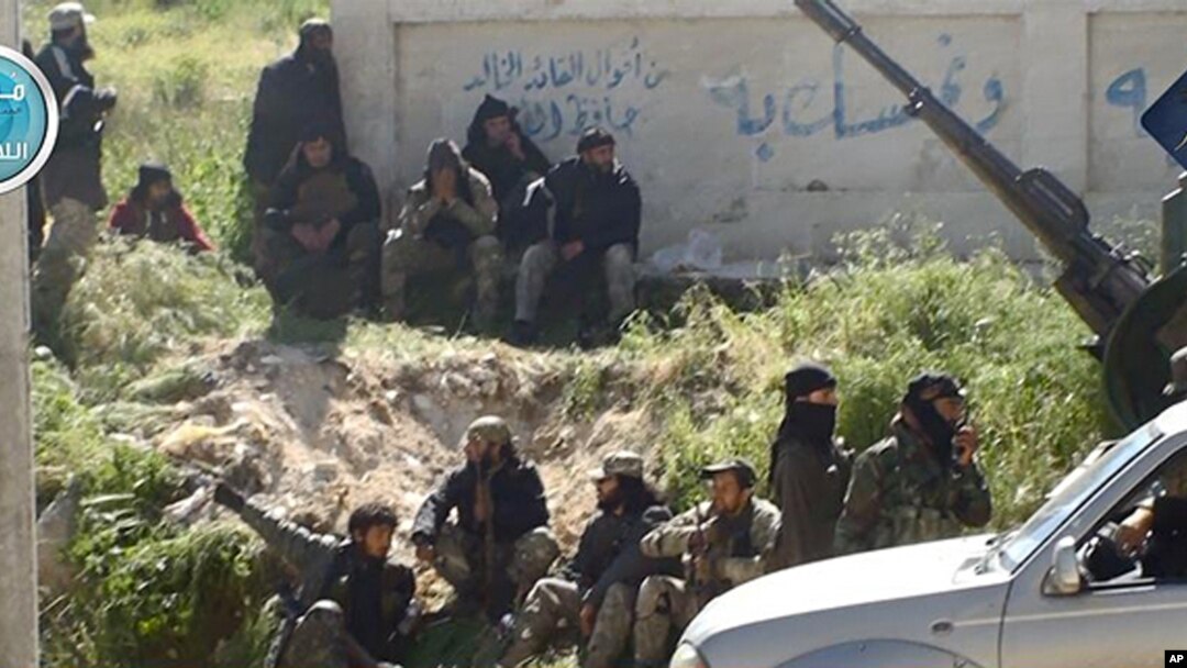This image posted on the Twitter page of Syria's al-Qaida-linked al-Nusra Front shows fighters from the group in the town of Jisr al-Shughour, Idlib province, Syria, April 25, 2015.