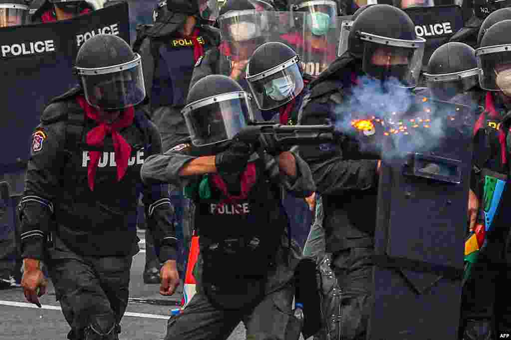 A riot policeman fires rubber bullets at protesters in a demonstration calling for the resignation of Thailand's Prime Minister Prayut Chan-O-Cha over the government's handling of the Covid-19 crisis in Bangkok.