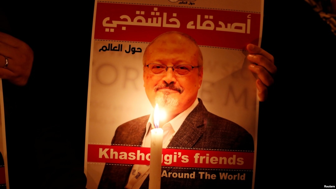 FILE - A demonstrator holds a poster with a picture of Saudi journalist Jamal Khashoggi outside the Saudi Arabia consulate in Istanbul, Turkey, Oct. 25, 2018.