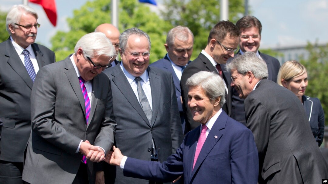 FILE - U.S. Secretary of State John Kerry, center, speaks with German Foreign Minister Frank-Walter Steinmeier, second left, and Greek Foreign Minister Nikos Kotzias, fourth left, during a group photo at NATO headquarters in Brussels.