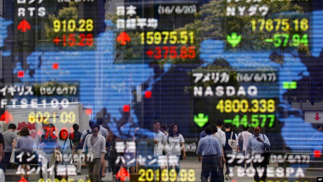 A securities firm's electronic stock indicator reflects pedestrians passing by in Tokyo, June 20, 2016. Global markets jumped Monday as polls suggest British voters on Thursday will choose to remain in the European Union. 