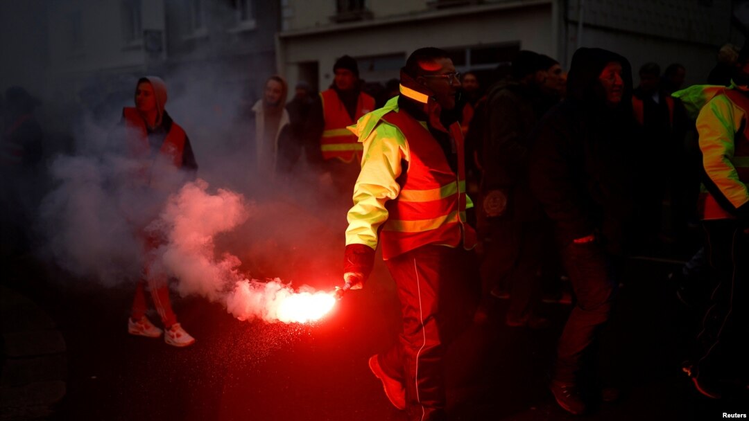 Protesters hold flares during a demonstration against French government's pension reform plan in Saint-Nazaire as part of a day of national strike and protests in France, Jan. 19, 2023.