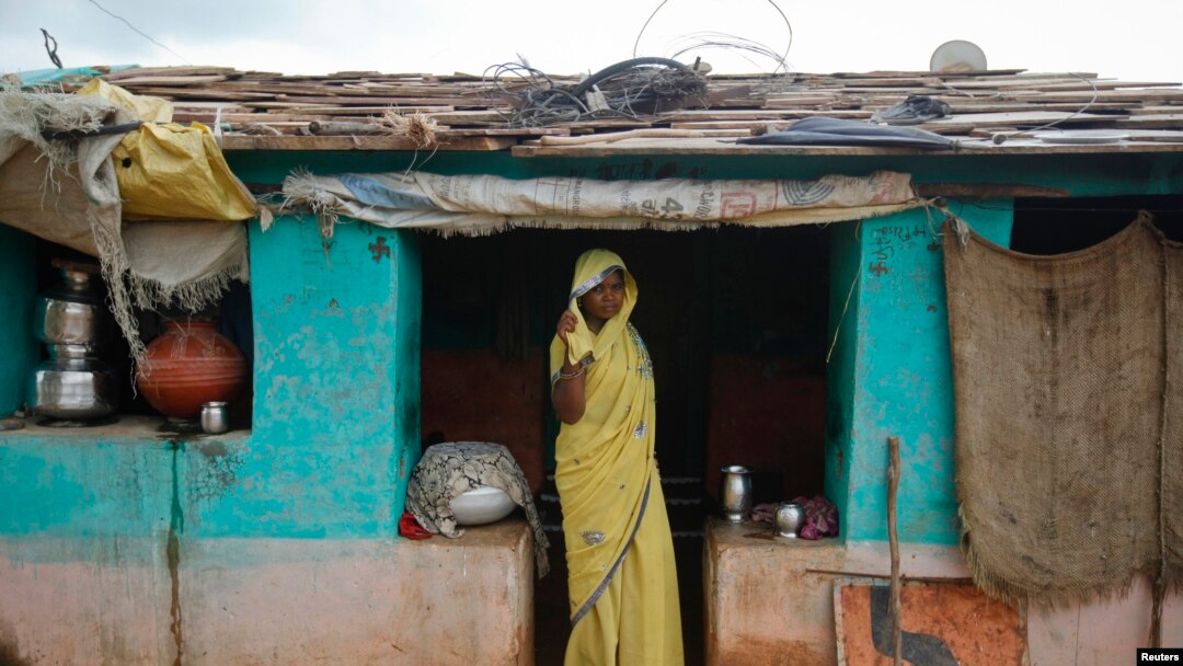 Child bride Krishna, 12, stands at a doorway into her compound in a village near Baran, in India's Rajasthan state, July 30, 2011. Only a quarter of policymakers came close to estimating child marriage rates in their countries, according to a study.