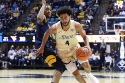 FILE - Akron's Tyler Cheese is defended by West Virginia's Taz Sherman during an NCAA college basketball game in Morgantown, West Virginia, November 8, 2019.