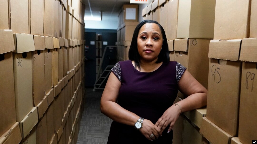 FILE - Fulton County District Attorney Fani Willis poses among boxes containing thousands of cases at her office, on Feb. 24, 2021, in Atlanta. 