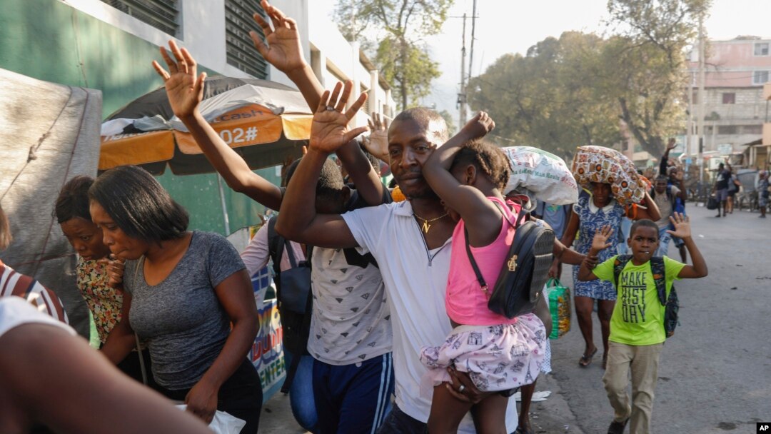 ARCHIVO - Vecinos huyen de sus casas durante los enfrentamientos entre la policía y miembros de una pandilla en el barrio de Portail en Puerto Príncipe, Haití, el jueves 29 de febrero de 2024.