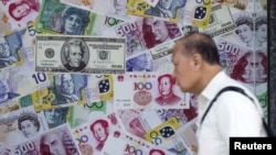 在香港的外匯商店，一名男子走過一個宣傳中國人民幣（RMB）和其他外國貨幣兌換服務的櫥窗（2015年8月13日）。
