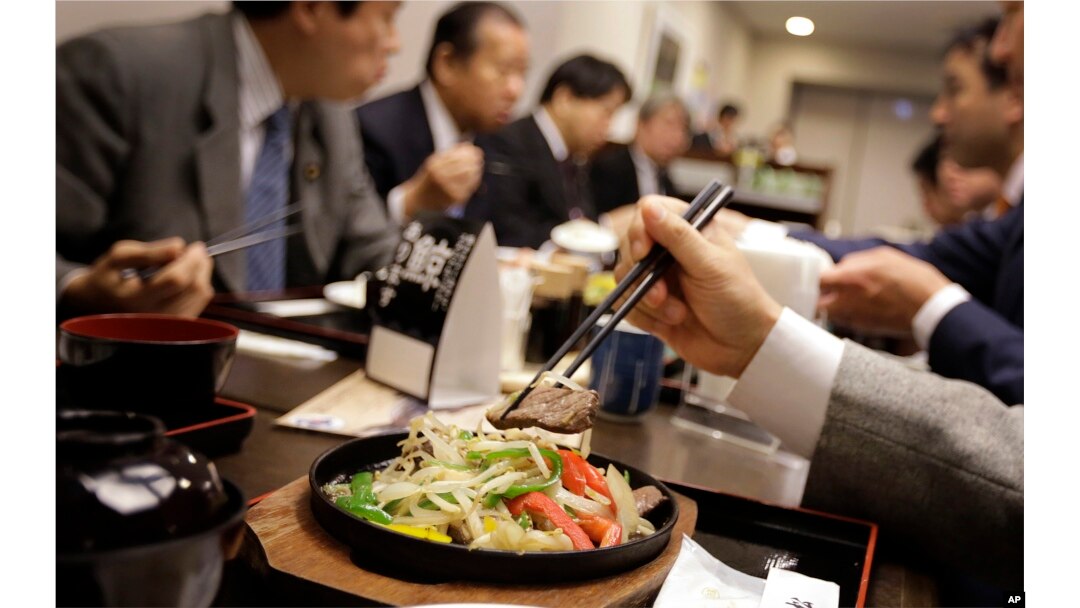 Lawmakers and government officials try whale meat dishes to promote whale meat at a dining room of Ministry of International Trade and Industry in Tokyo Wednesday, Nov. 19, 2014.